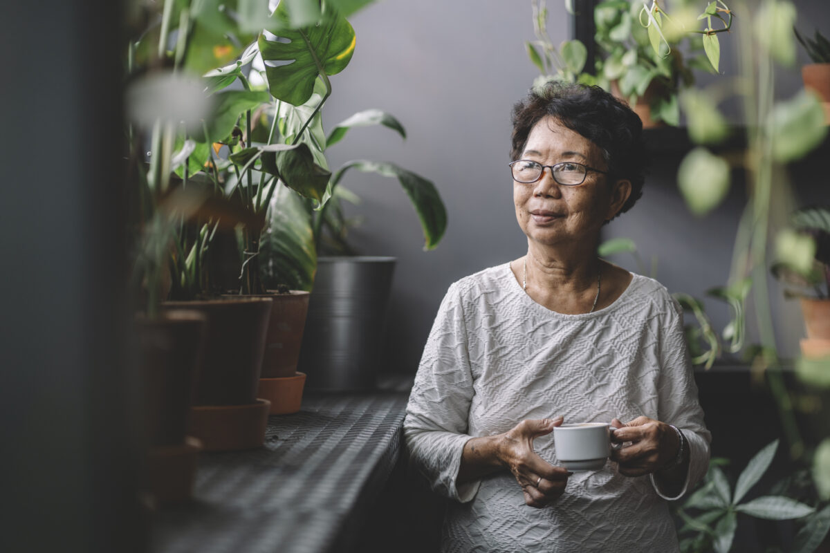 Elderly woman looking standing next to a window
